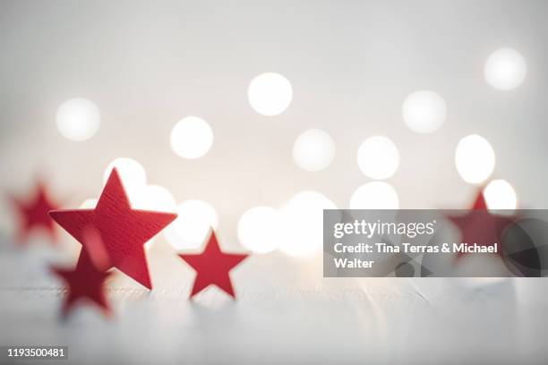 christmas background with red stars with fairy lights. copy space. christmas mood. - wooden floor background stock pictures, royalty-free photos & images