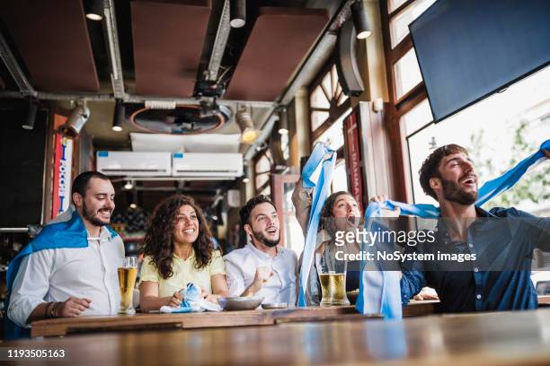 colleagues gathering in the pub after work, watching a soccer game - football argentine stock pictures, royalty-free photos & images