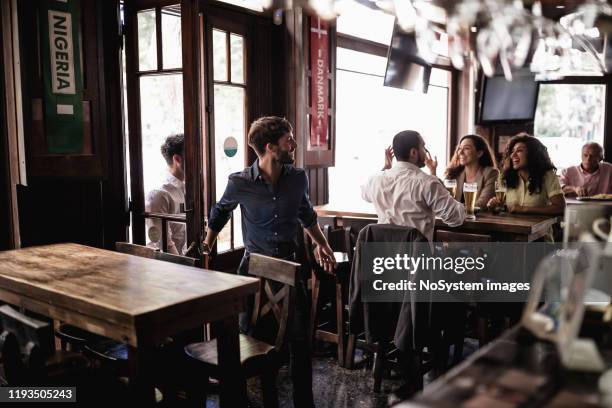 vrienden verzamelen in pub, kijken naar een voetbalwedstrijd - cafe counter stockfoto's en -beelden