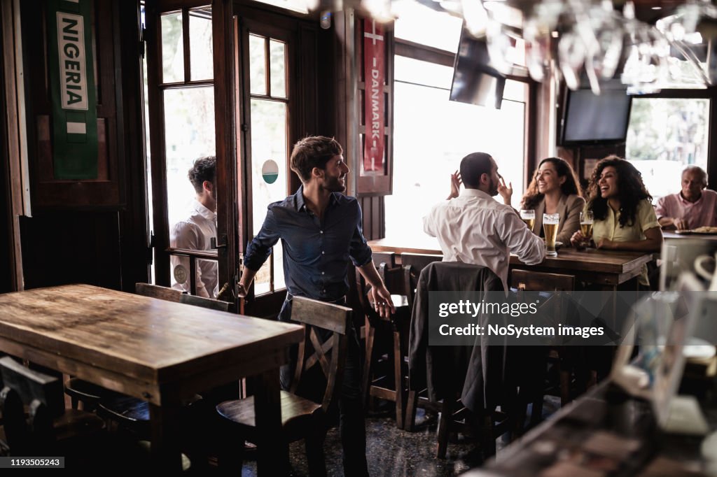 Friends gathering in pub, watching a soccer game