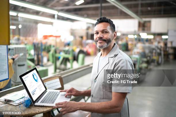 portrait of a technician using laptop in the production line of a factory - pardo brazilian stock pictures, royalty-free photos & images