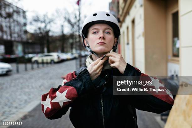 young woman putting on helmet before going out on bike - met 2019 photos et images de collection