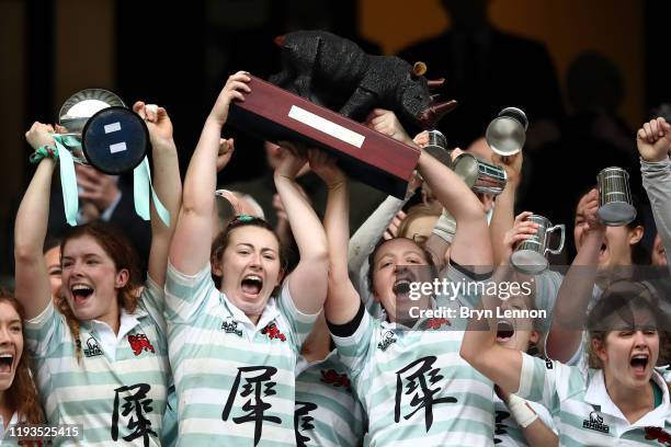 Fiona Shuttleworth, Bluebell Nicholls and Alice Elgar of Cambridge celebrate as they lift the trophy after winning the Women's Varsity Game between...