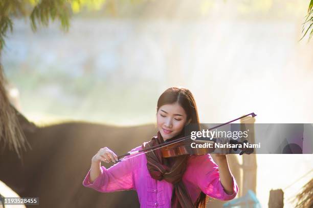 music,melody,song concept. asian beautiful girl playing a violin with happiness. women enjoy playing music - violinist stock pictures, royalty-free photos & images