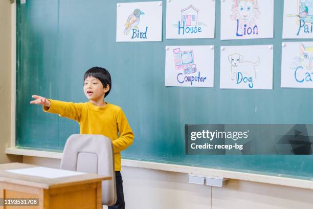 gruppe von schulkindern, die englisch lernen, während sie spiele spielen - japanisch sprache stock-fotos und bilder