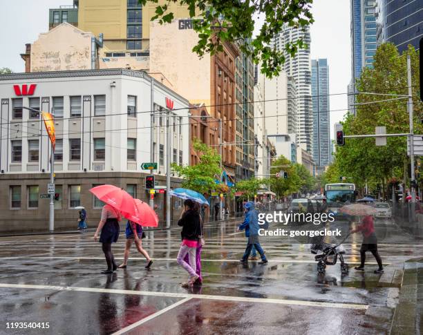 pedestrians in the rain in sydney - torrential rain umbrella stock pictures, royalty-free photos & images