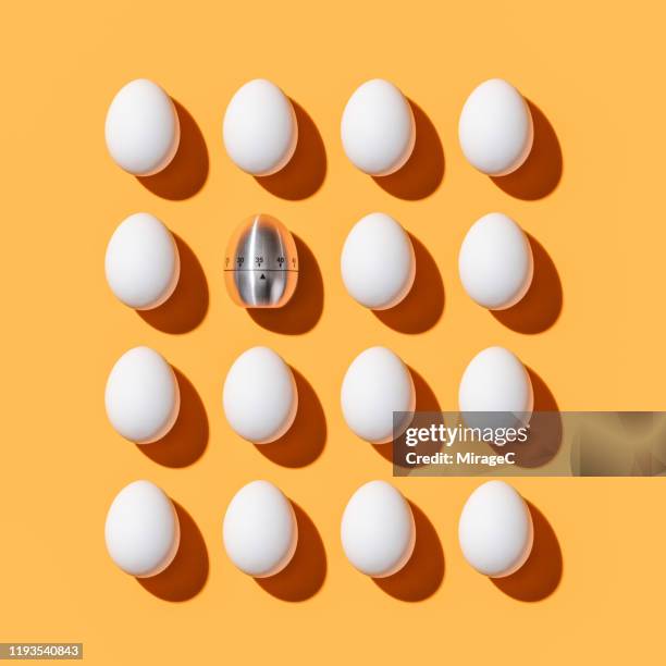 egg shaped timer among white eggs - countdown concept stock pictures, royalty-free photos & images