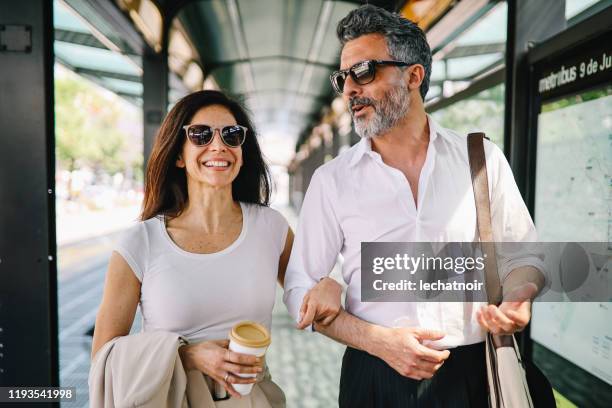 ブエノスアイレス駅で歩いて笑顔の成熟したカップル - elegant couple ストックフォトと画像