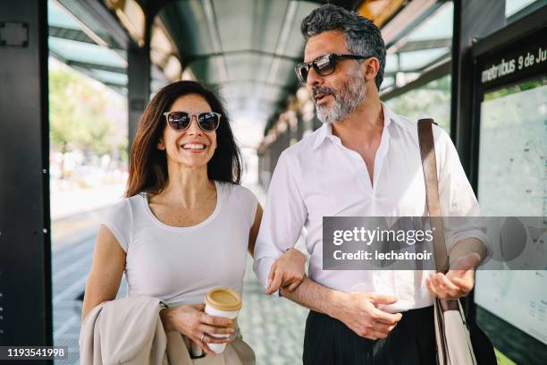 volwassen paar wandelen en glimlachen in het treinstation van buenos aires - elegant couple stockfoto's en -beelden