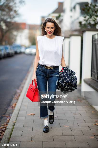 Alexandra Lapp is seen wearing dark denim blue jeans AG Jeans, white sleeveless muscle tshirt with padded shoulders The Frankie Shop, Gucci GG...