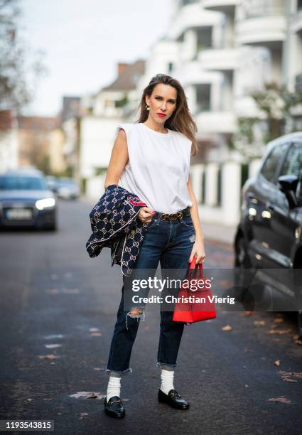 Alexandra Lapp is seen wearing dark denim blue jeans AG Jeans, white sleeveless muscle tshirt with padded shoulders The Frankie Shop, Gucci GG...