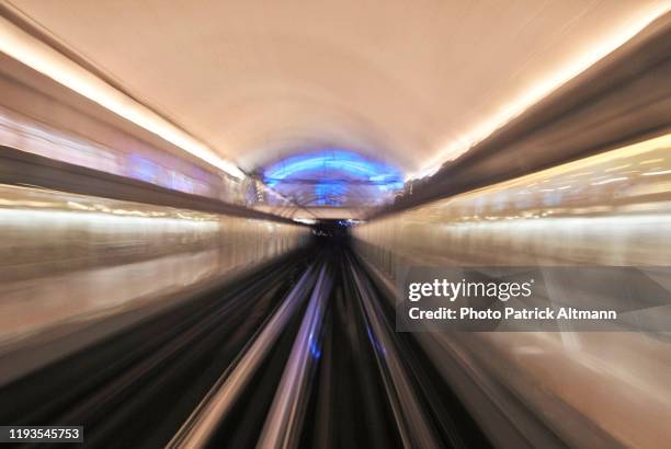 paris metro's (subway, underground) train in motion arriving at station photographed in long exposure (slow shutter speed) shot from front car in driverless train - fast shutter speed stock-fotos und bilder