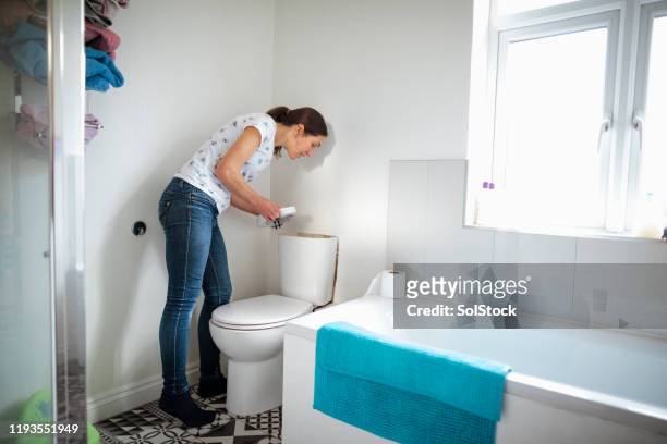 checking the cistern - woman toilet stock pictures, royalty-free photos & images