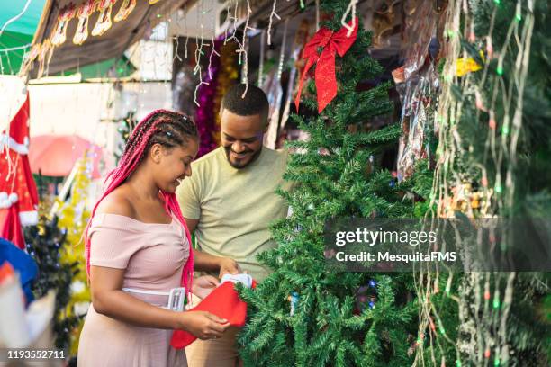 afro-paar kauft weihnachtsschmuck im outdoor-shop - chrismas brasil stock-fotos und bilder