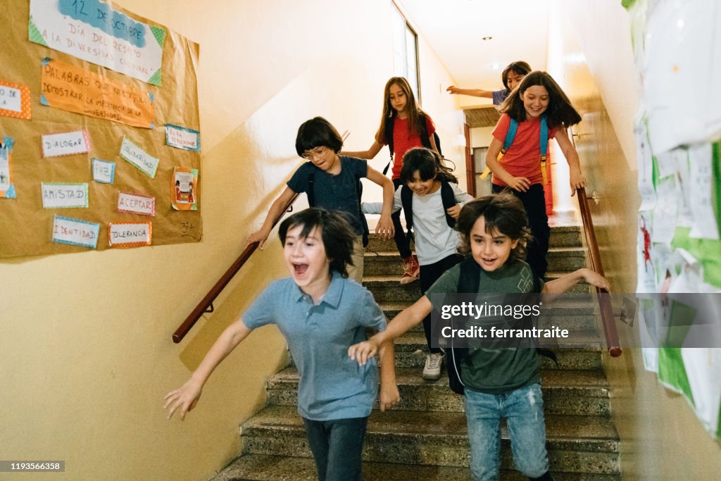Elementary age Students running in school corridors on the last day of school