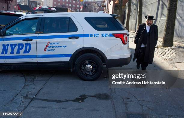 An Hasidic man walks past a patrol car on December 12, 2019 in the Williamsburg neighborhood of Brooklyn, New York.