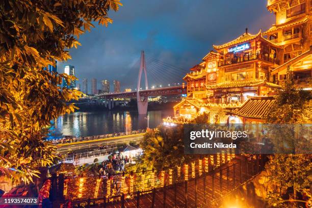 hongyadong hillside buildings and river with bridge in chongqing, china - chongqing hongyadong stock pictures, royalty-free photos & images