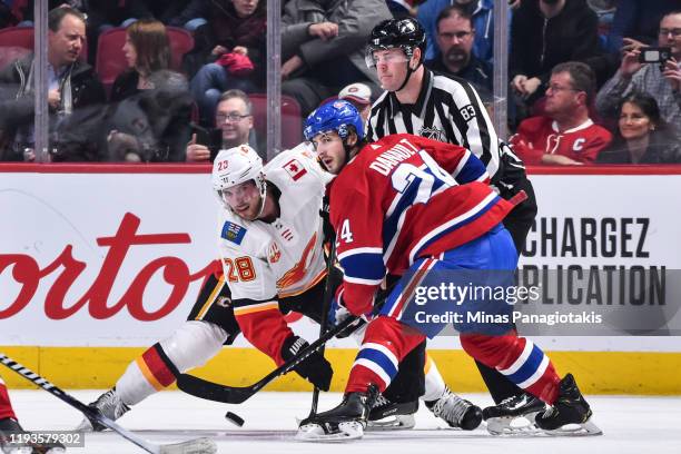 Phillip Danault of the Montreal Canadiens wins the faceoff against Elias Lindholm of the Calgary Flames during the first period at the Bell Centre on...
