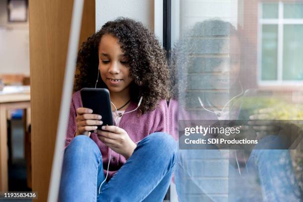 middelbare schoolmeisje horloges video op slimme telefoon - child phone stockfoto's en -beelden