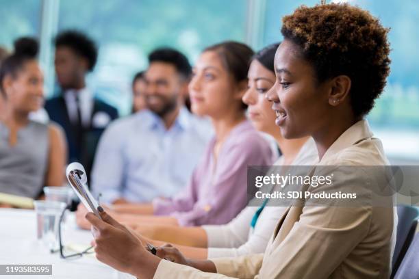 african american businesswoman takes notes during meeting - town hall stock pictures, royalty-free photos & images