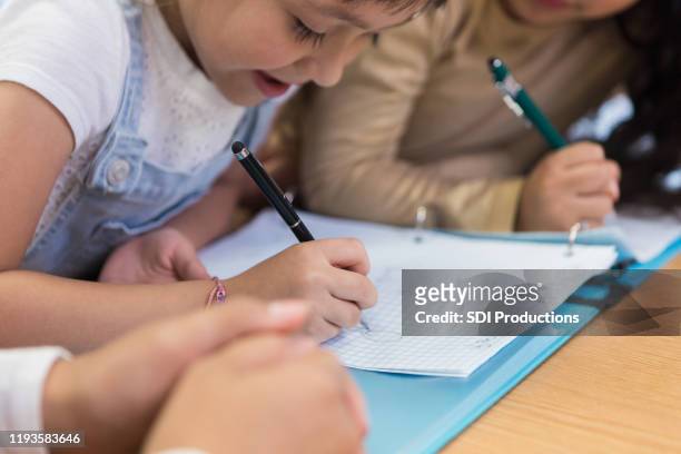 young girl studies with friends - children looking graph stock pictures, royalty-free photos & images