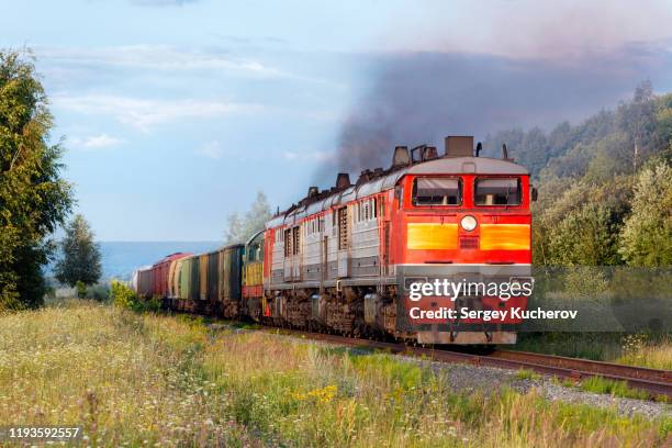 powerful diesel locomotive hauling a heavy freight train - shipping containers green red stock-fotos und bilder