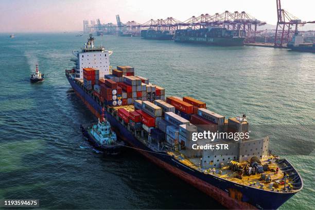 Cargo ship loaded with containers makes its way at a port in Qingdao in China's eastern Shandong province on January 14, 2020. China's trade surplus...