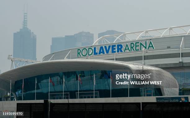 Smoke haze from unprecendented bushfires hover over the Rod Laver Arena ahead of the Australian Open in Melbourne on January 14, 2020. - Soaring...