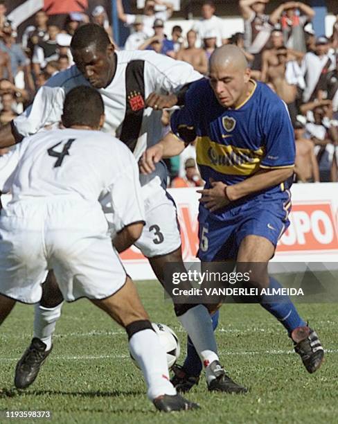 Argentine striker from Boca Juniors, Perez , fights for the ball with Odvan and Torres , of Vasco da Gama, during their Copa Mercosur game at Mane...