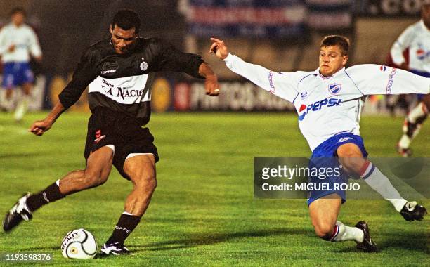 Olimpia's forward, Escobar , fights for the ball with Nacional's defense player, Adalto, during their Copa Mercosur game, 28 July 2001 in Montevideo,...