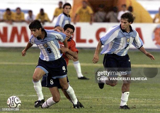 Alejandro Dominguez fights Chilean Nelson Pinto for the ball while Cristian Gimenez of Argentina watches during a match at the South American Soccer...