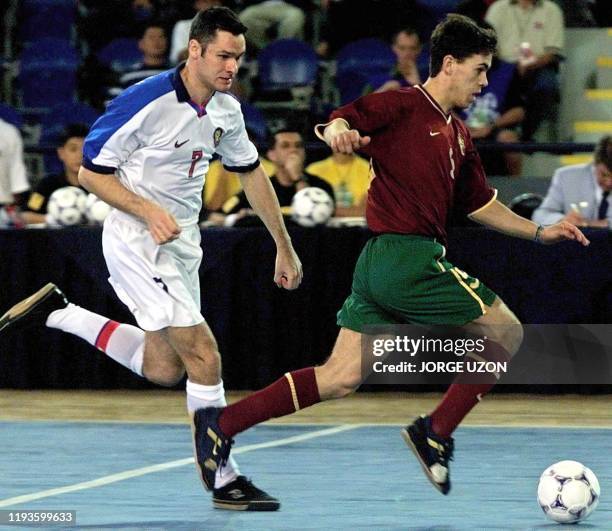 Markin Mikhail of Russia pursues Arnaldo of Portugal 03 December 2000 in their indoor soccer match. Markin Mikhail del seleccionado de Rusia persigue...