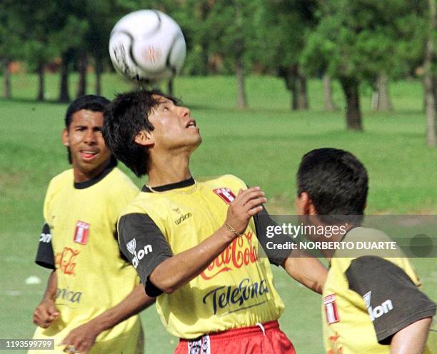 Peruvian Jose Pereda Maruyama plays with a ball under a glance of his teammate Abel Lobaton Mirror 13 November 2000 in Asuncion, Paraguay, during a...