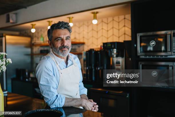 bartender leaning on the counter - bartender portrait stock pictures, royalty-free photos & images