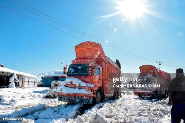 Trucks struggle to go through snow on a main highway after heavy snowfall in Khanozai area some 75 kms in northeast of the provincial capital Quetta...