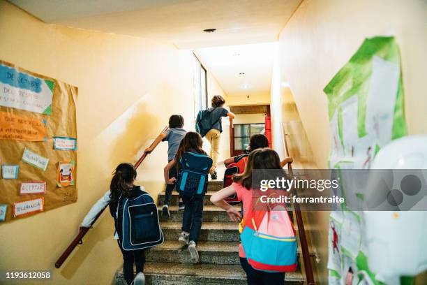 groep van elementaire leeftijd studenten gaan naar de klas - school boy with bag stockfoto's en -beelden