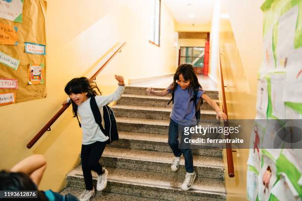 elementary age students running in school corridors on the last day of school - last day of school stock pictures, royalty-free photos & images