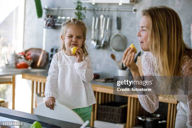 making funny faces while tasting raw lemons - sour expression stock pictures, royalty-free photos & images