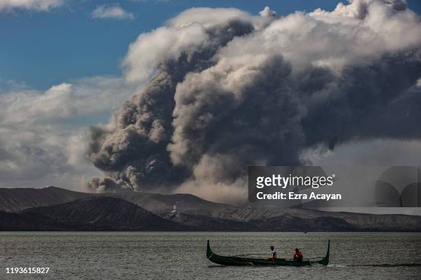 Fishing boat sails along a lake as Taal Volcano erupts on January 14, 2020 in Talisay, Batangas province, Philippines. The Philippine Institute of...