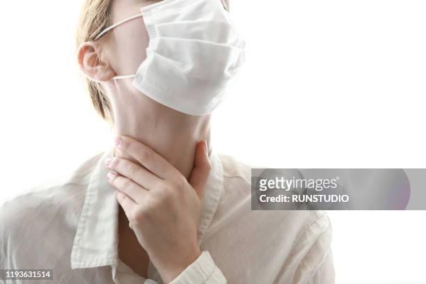 young woman wearing flu mask and sore throat - tokyo covered by haze stockfoto's en -beelden