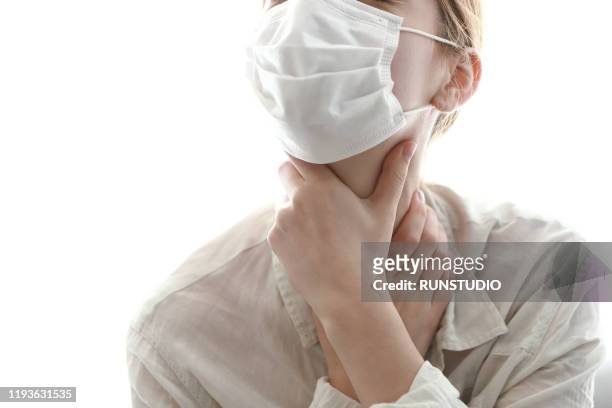 woman wearing flu mask and sore throat - tokyo covered by haze stockfoto's en -beelden