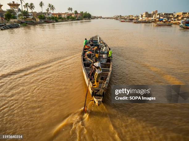 Boatman rows his boat on River Senegal in Saint Louis. Saint Louis in Senegal is one of the places on Earth the most affected by the climate change....