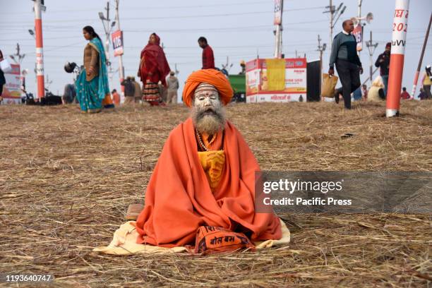 Sadhu offering prayer after taking holy dip at Sangam, the confluence of three sacred rivers the Yamuna, the Ganges and the mythical Saraswati,...