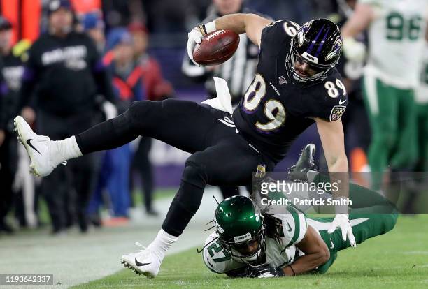 Tight end Mark Andrews of the Baltimore Ravens is tripped by cornerback Darryl Roberts of the New York Jets during the game at M&T Bank Stadium on...