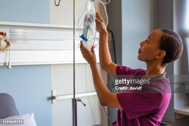 weibliche krankenschwester einrichtung iv medizinische geräte - preparing drug in hospital nurse stock-fotos und bilder