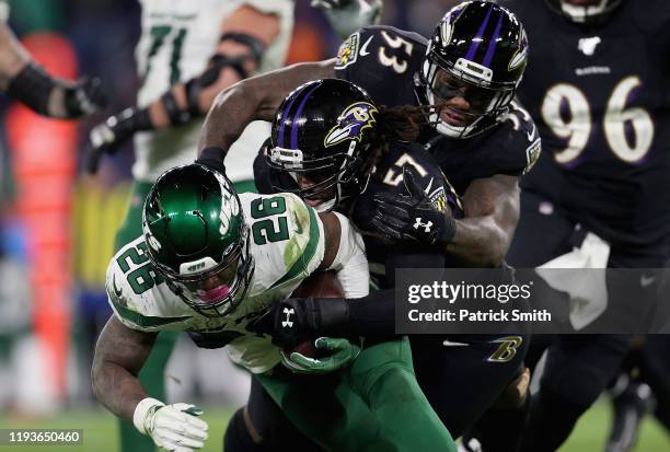 Running back Le'Veon Bell of the New York Jets is tackled by the defense of middle linebacker Josh Bynes and defensive end Jihad Ward of the...