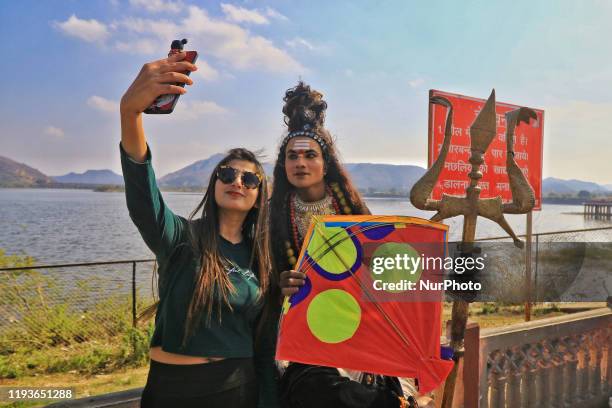 Girl take selfie with dress up artist during the Kite Festival on the occasion of the Makar Sakranti Festival at Jal Mahal in Jaipur, Rajasthan,...