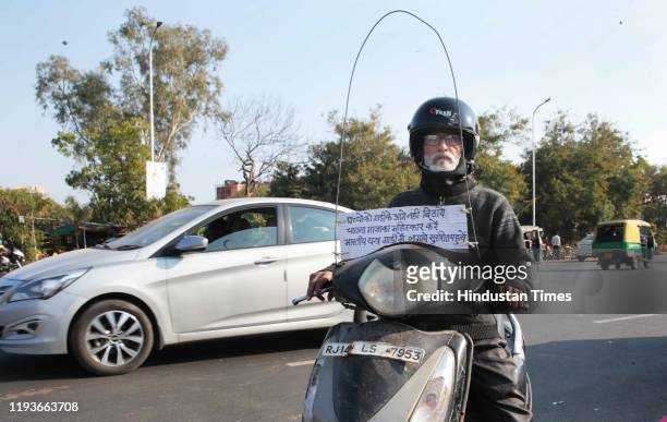 Two wheeler rider with a makeshift innovation and an awareness message against the use of glass coated manjha thread used to fly kites, on the eve of...