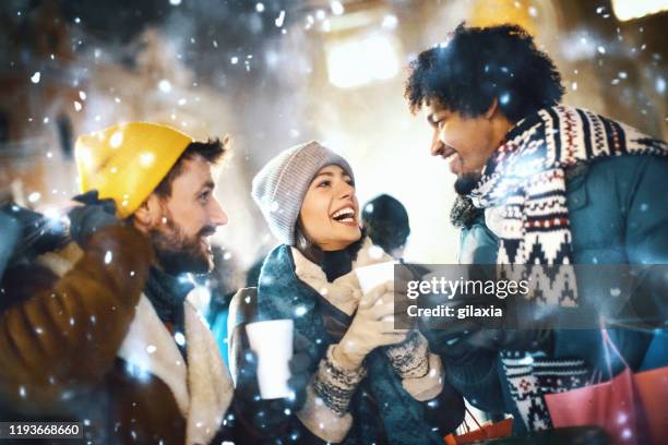 friends having fun on a snowy december night. - snow fun stock pictures, royalty-free photos & images