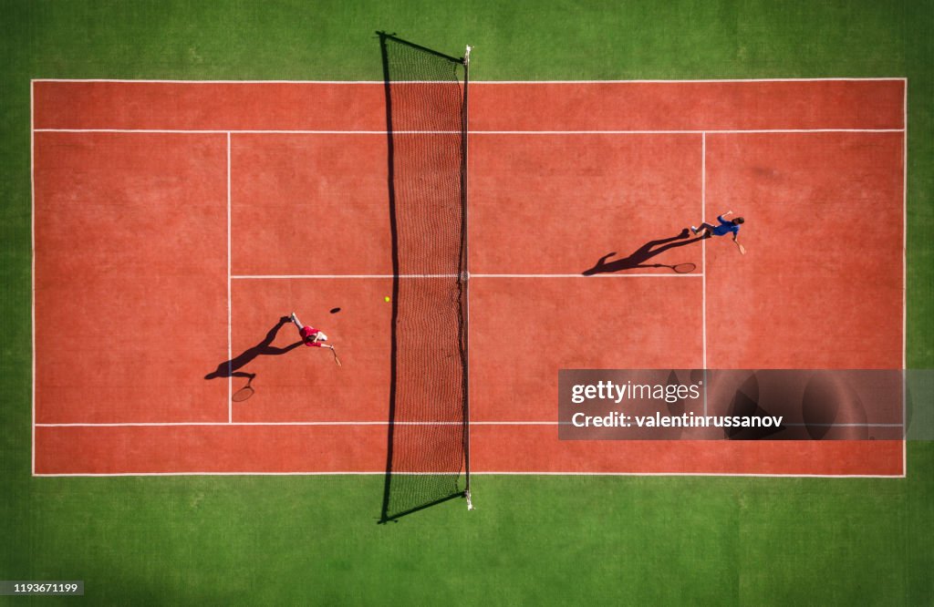 Vue de drone du match de tennis d'en haut avec l'ombre du joueur